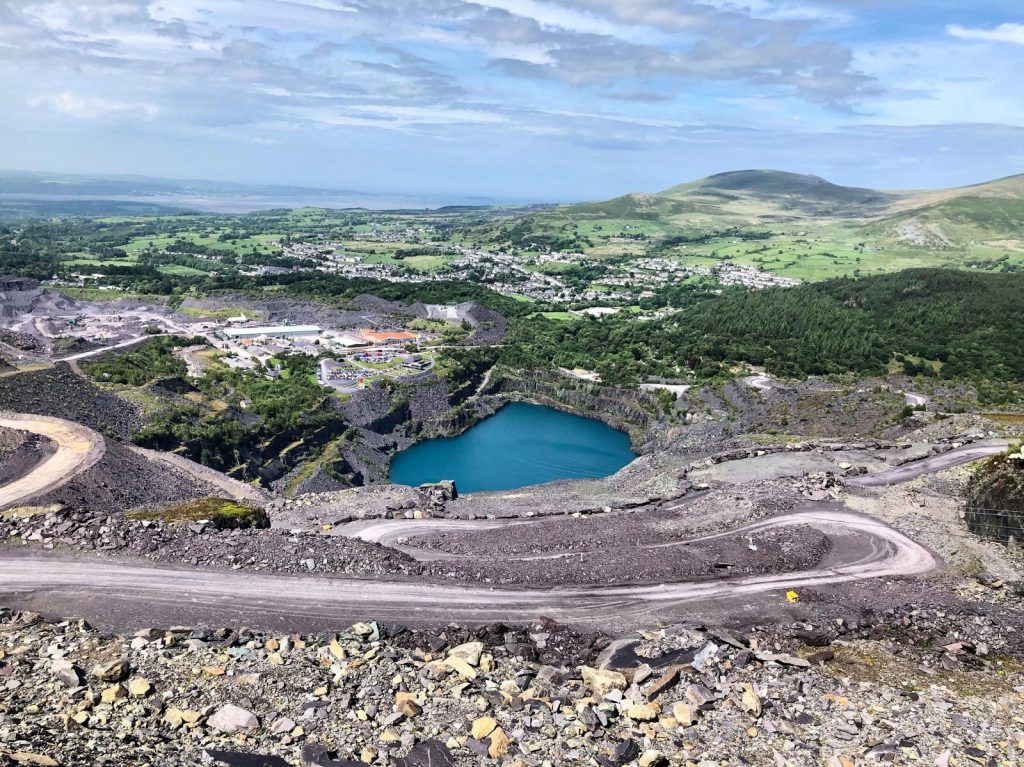 aerial view of lake in the middle of green mountains during daytime