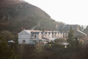 a group of houses sitting on top of a lush green hillside